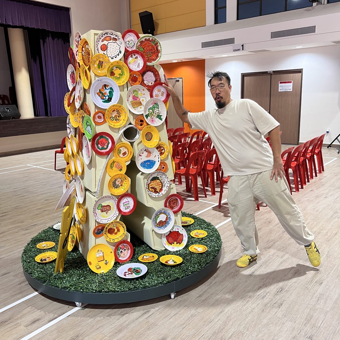 A Legion maker beside the finished Kiap Kiap community installation, a giant wooden clothes peg studded with resident-painted plates