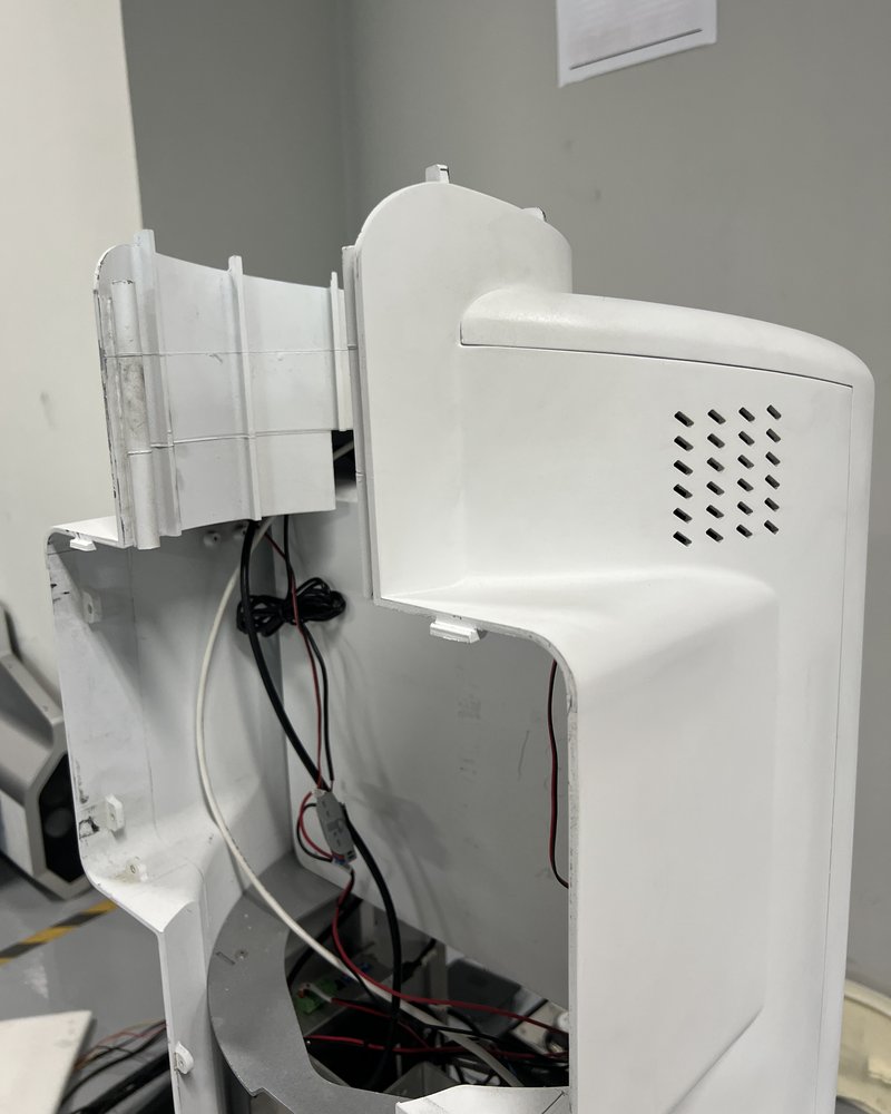 A white robotics housing opened in the workshop for repair, internal wiring visible