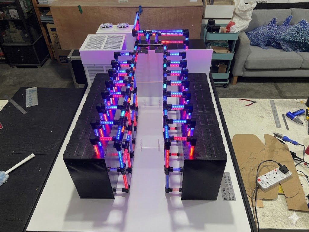 Illuminated data-centre cooling system model with colour-coded red and blue flow lines, built for Delta Electronics