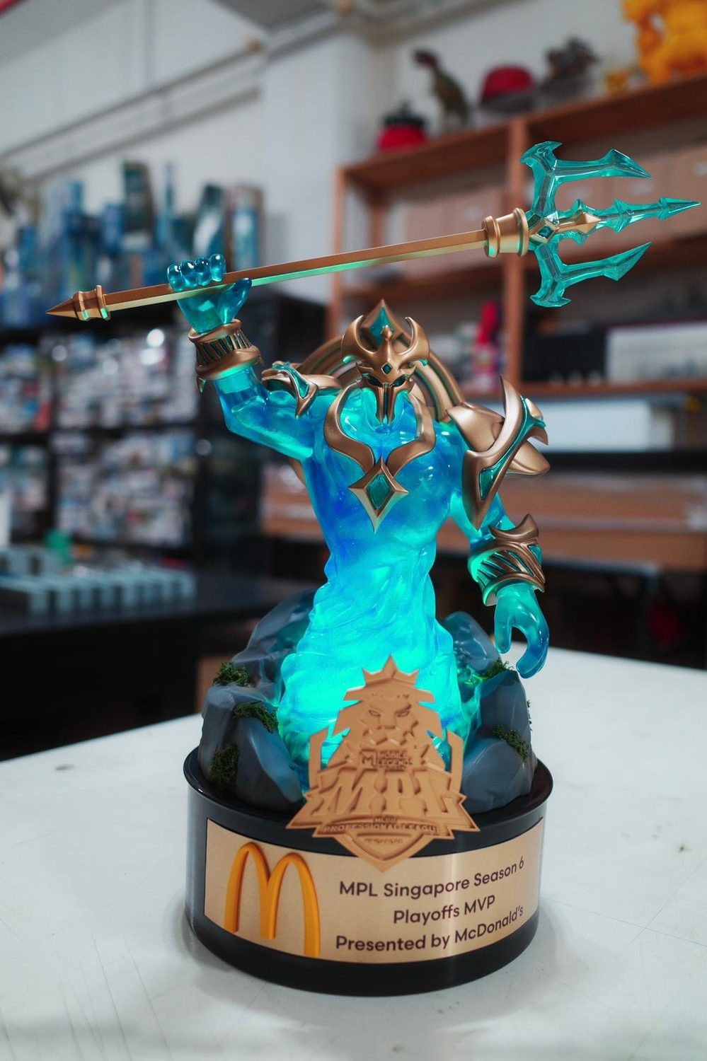 The illuminated MPL Singapore Season 6 Playoffs MVP trophy, a glowing figure raising a trident